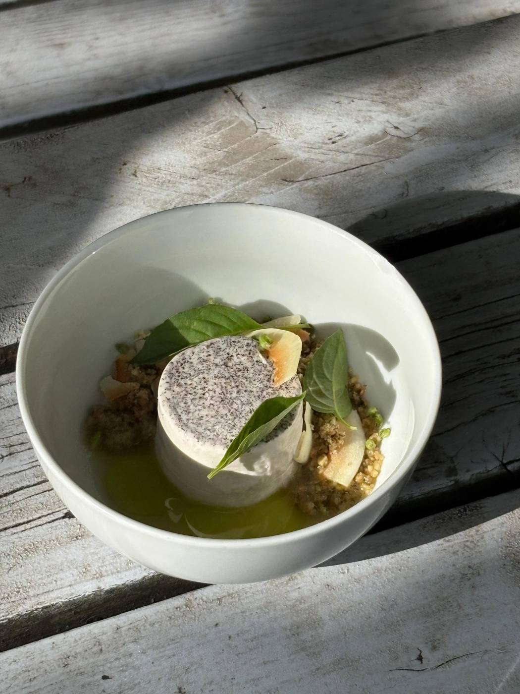 A small dish in a white bowl, in deep shadow